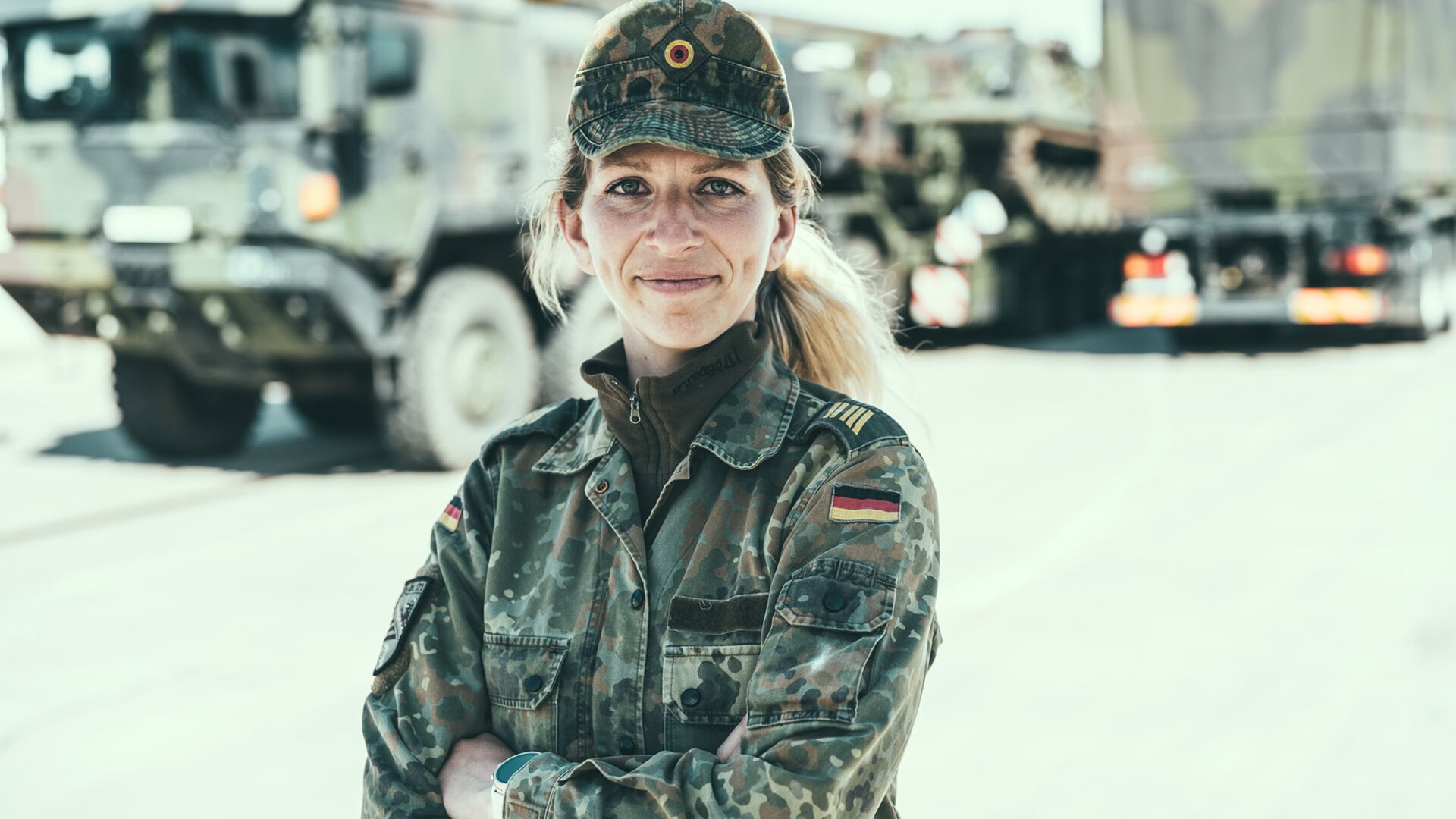 Eine Soldatin der Logistiktruppe steht vor einem militärischen LKW